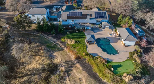 an aerial view of a house with a yard and lake view