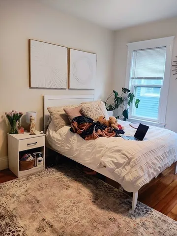 a bedroom with a bed and a potted plant