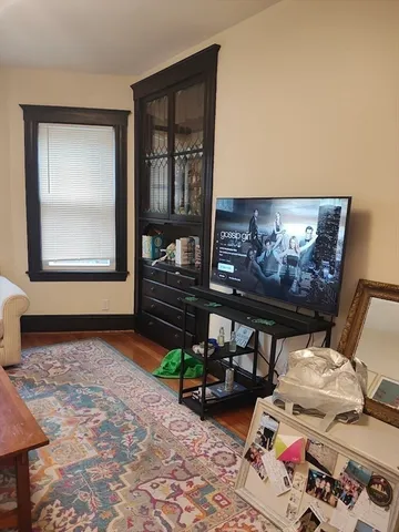 a living room with furniture a rug and a wall painting