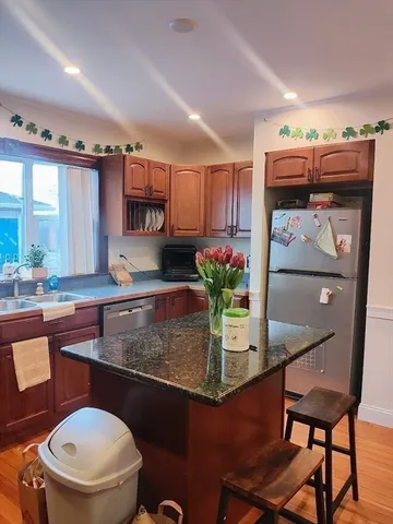 a kitchen with stainless steel appliances granite countertop a sink and a refrigerator