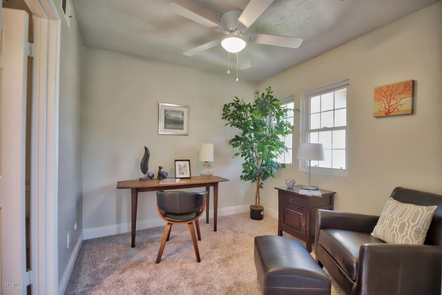 a work room with furniture and a potted plant