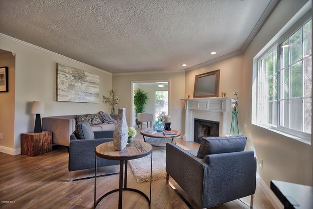 a living room with furniture a fireplace and a large window