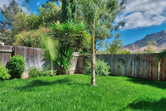 a backyard of a house with plants and wooden fence