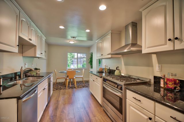 a kitchen with stainless steel appliances a sink stove and cabinets