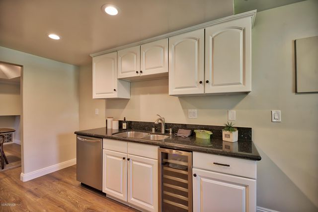 a kitchen with granite countertop white cabinets and a stove a sink