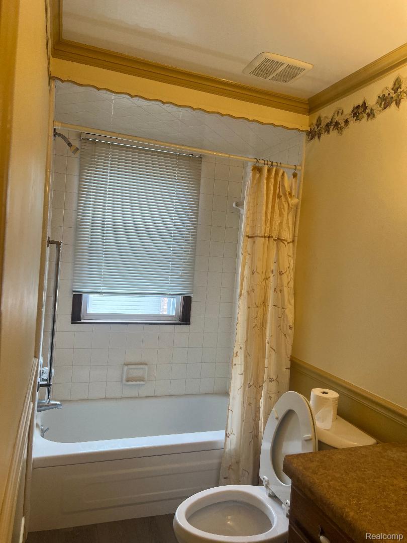 149 Roth Boulevard Clawson, MI 48017 - Photo 12 of 20 White tiled bathtub and shower combination with a window featuring horizontal blinds