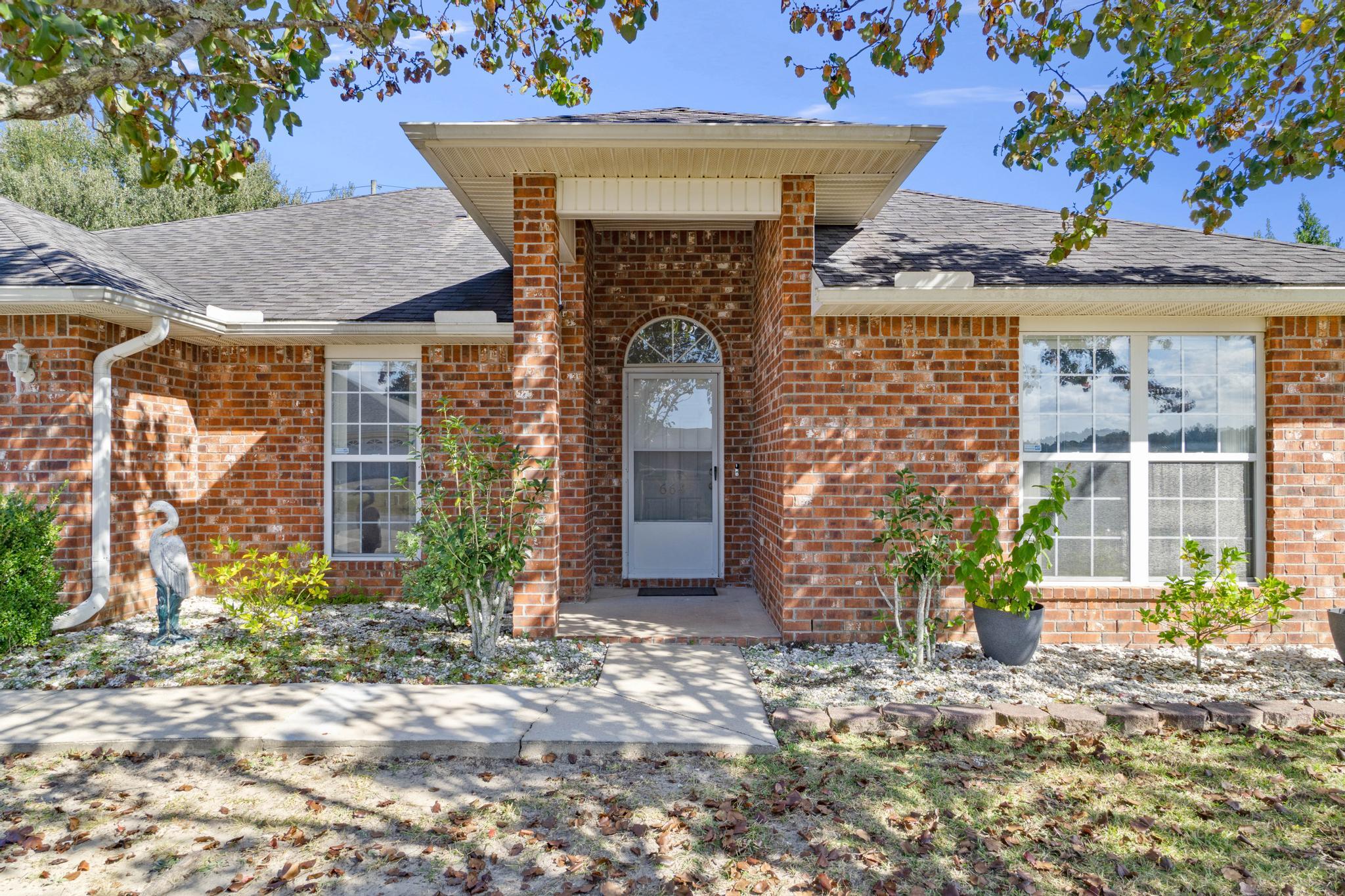 664 Brunson Street Crestview, FL 32536 - Photo 1 of 49 a front view of a house with garden