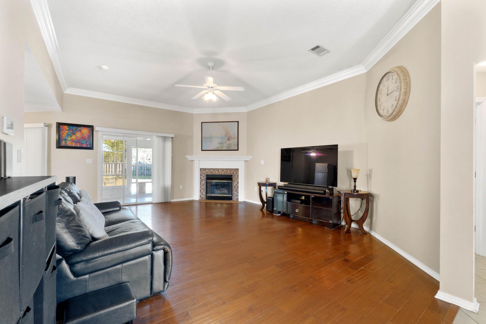 664 Brunson Street Crestview, FL 32536 - Photo 16 of 49 a living room with furniture a fireplace and a flat screen tv