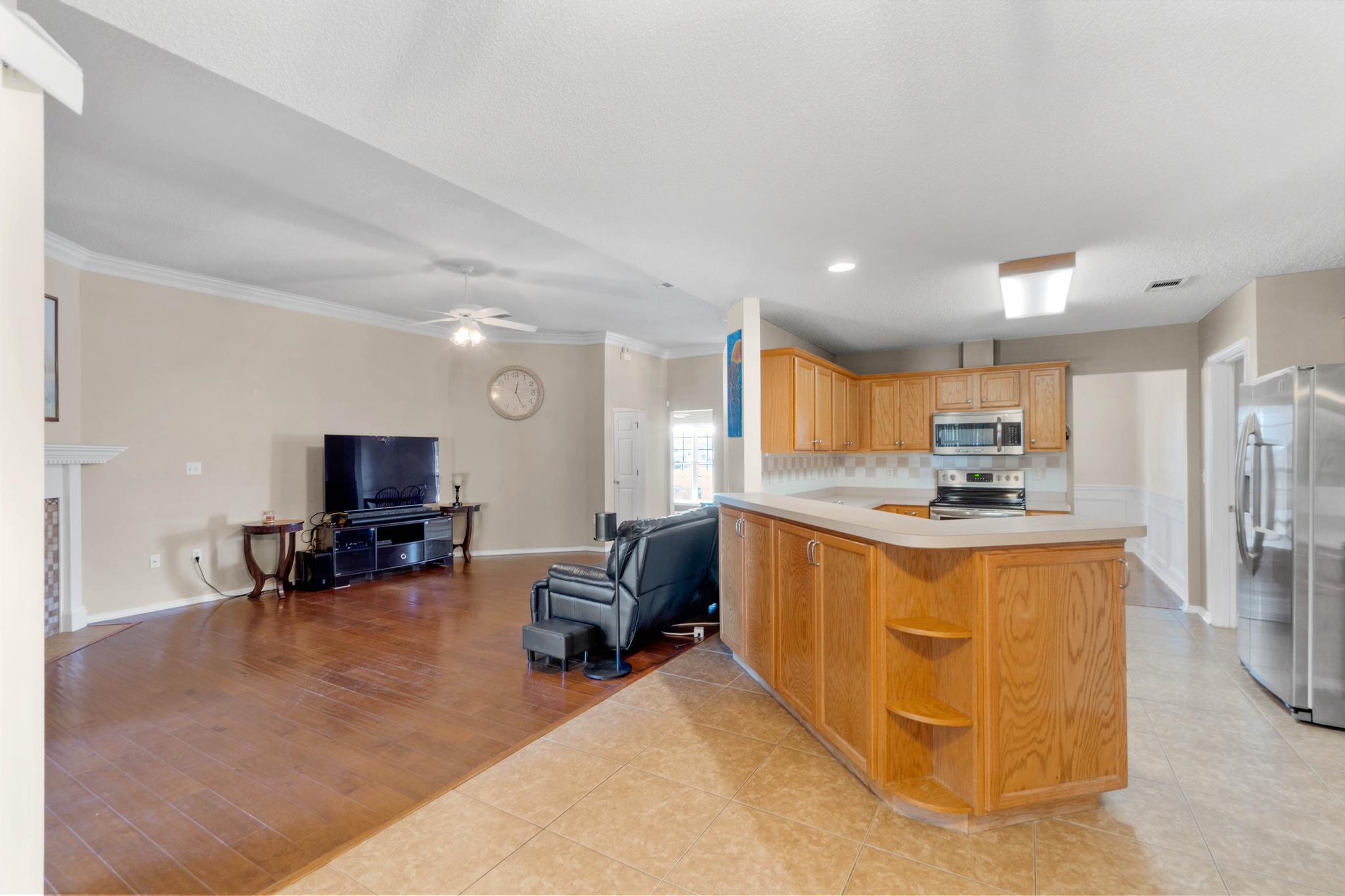 664 Brunson Street Crestview, FL 32536 - Photo 19 of 49 a kitchen with stainless steel appliances kitchen island granite countertop a sink and a refrigerator