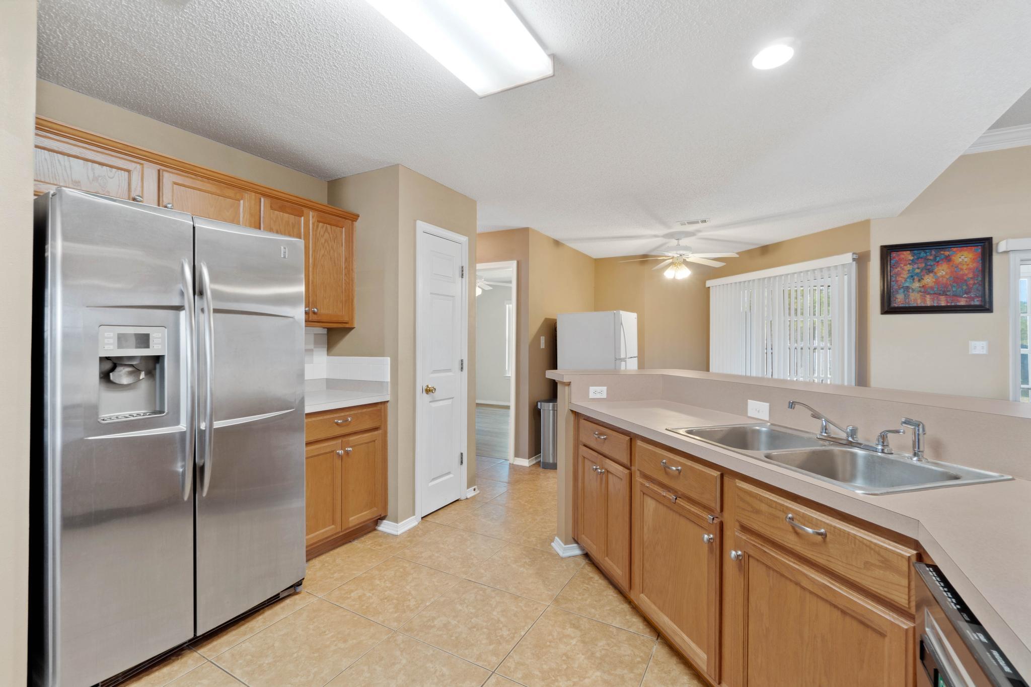 664 Brunson Street Crestview, FL 32536 - Photo 20 of 49 a kitchen with stainless steel appliances granite countertop a refrigerator and a sink