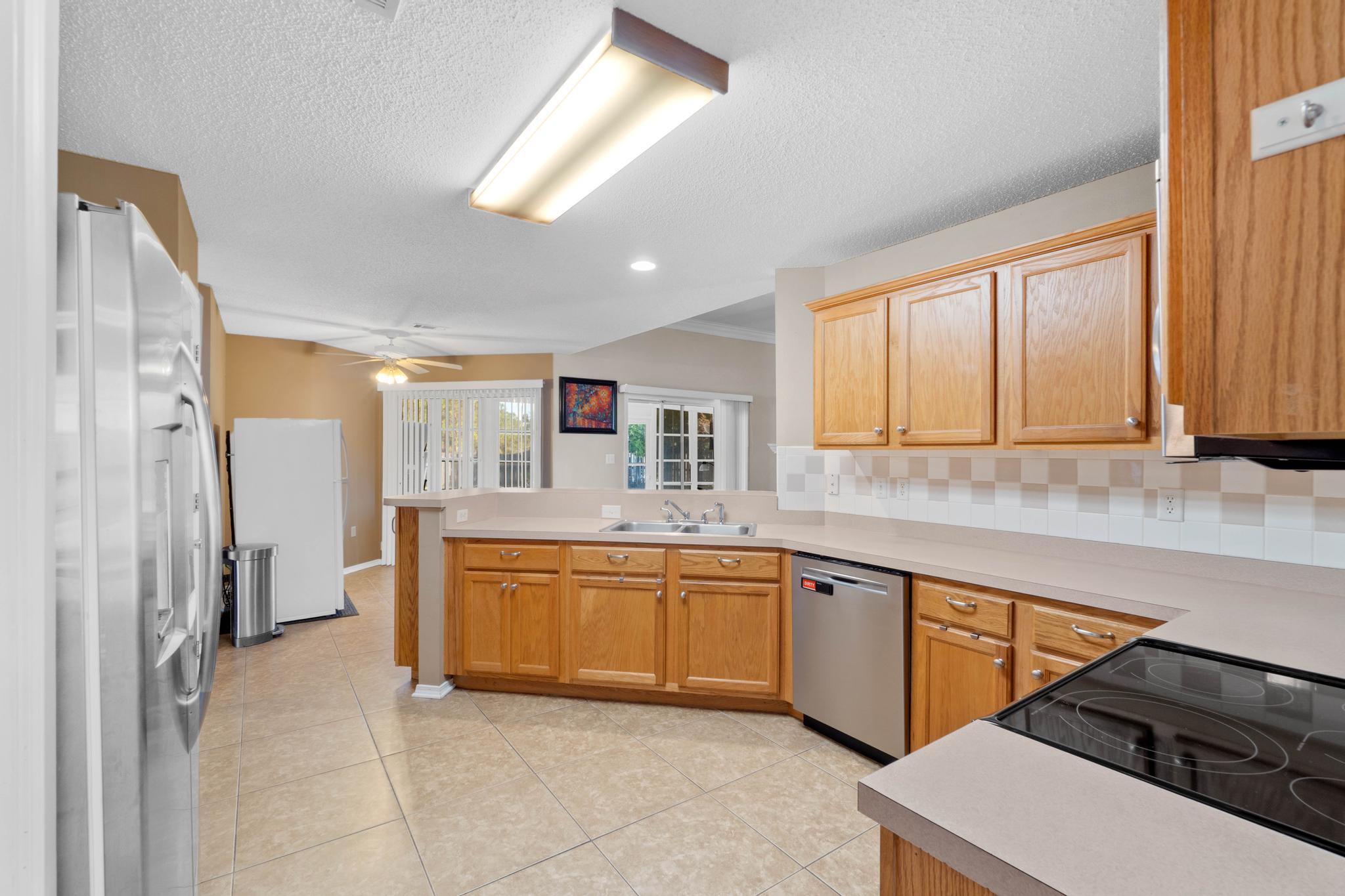 664 Brunson Street Crestview, FL 32536 - Photo 21 of 49 a large kitchen with stainless steel appliances granite countertop a sink and a stove