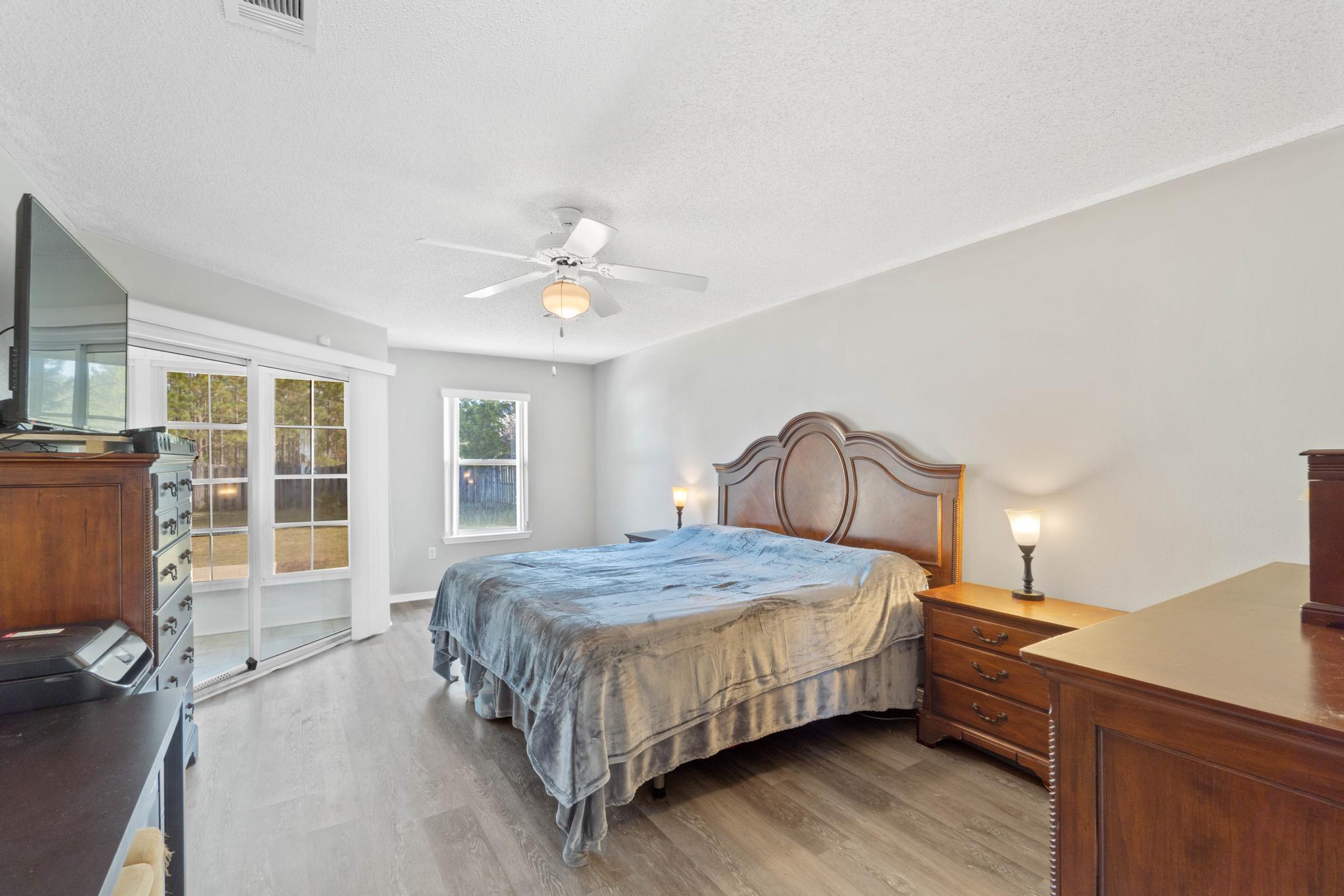 664 Brunson Street Crestview, FL 32536 - Photo 24 of 49 a bedroom with a bed wooden floor and window