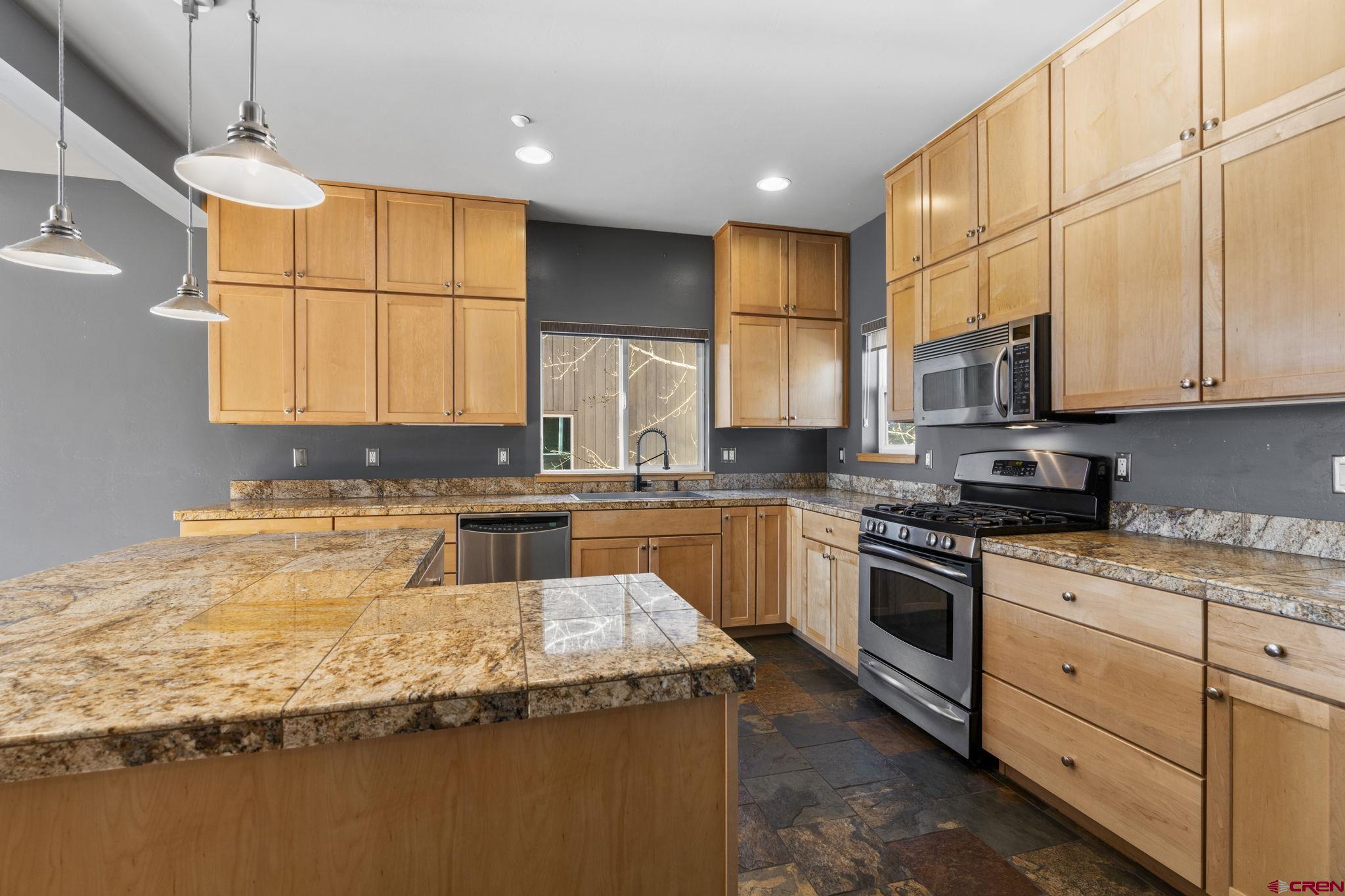 580 Animas View Drive, Unit 1 Durango, CO 81301 - Photo 12 of 43 a kitchen with granite countertop a sink a counter space appliances and cabinets
