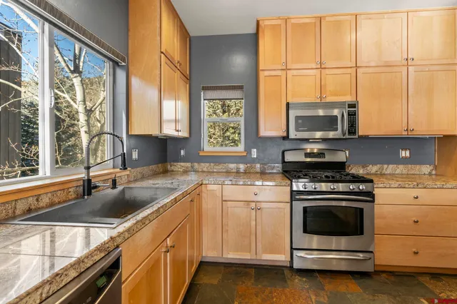 a kitchen with stainless steel appliances a stove sink and microwave