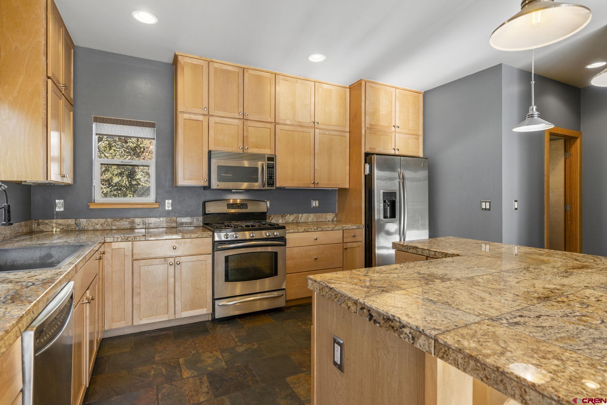 580 Animas View Drive, Unit 1 Durango, CO 81301 - Photo 15 of 43 a kitchen with stainless steel appliances granite countertop a stove a sink and a refrigerator