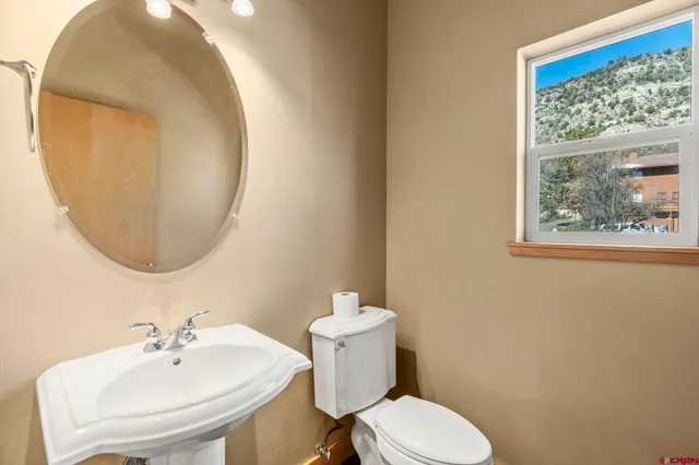 a bathroom with a toilet sink and mirror