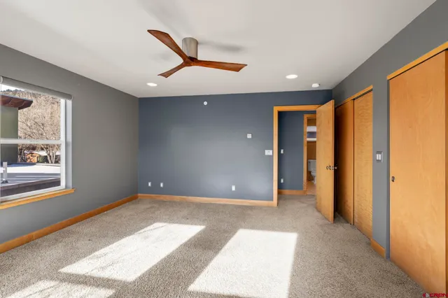 an empty room with windows and closet