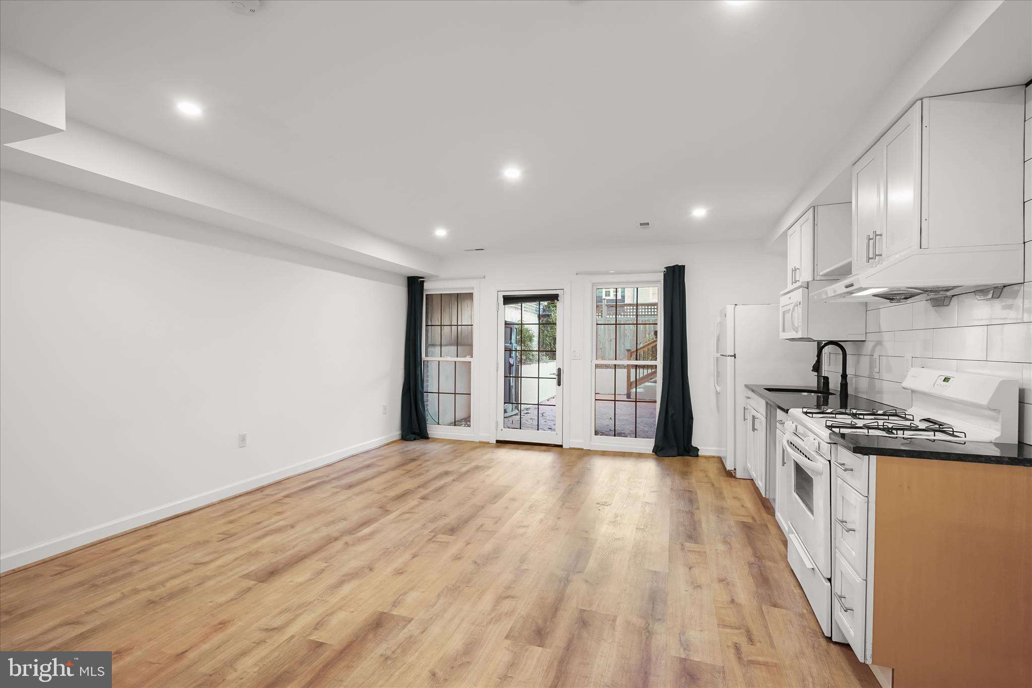 3626 T Street Northwest Washington, DC 20007 - Photo 35 of 61 a view of a kitchen with stainless steel appliances granite countertop a stove top oven a sink dishwasher and a refrigerator with wooden floor