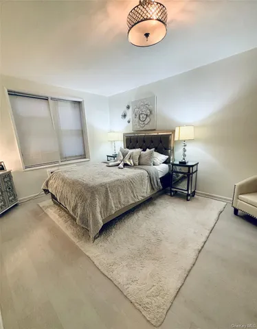 a bedroom with a bed and chandelier