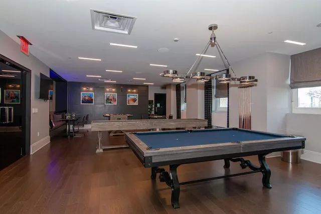 a room with furniture pool table and flat screen tv