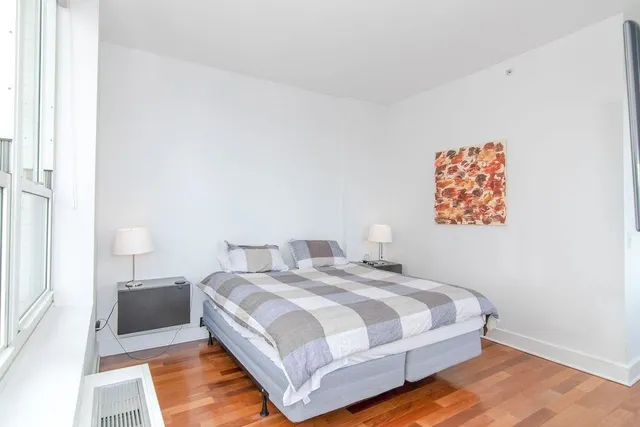 a bedroom with a bed and a painting on the wall