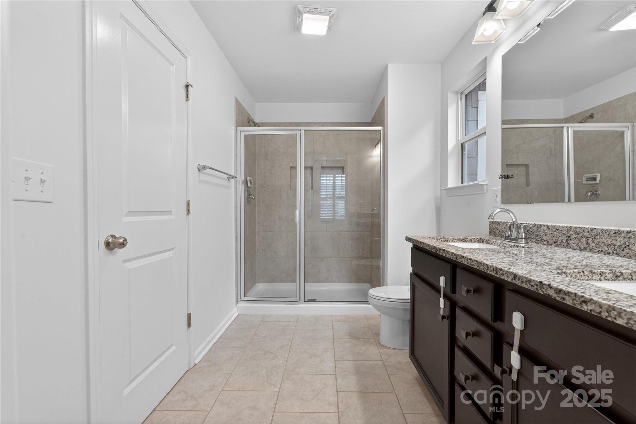 7481 Hartsfield Drive Lancaster, SC 29720 - Photo 27 of 47 a bathroom with a granite countertop sink a toilet and shower