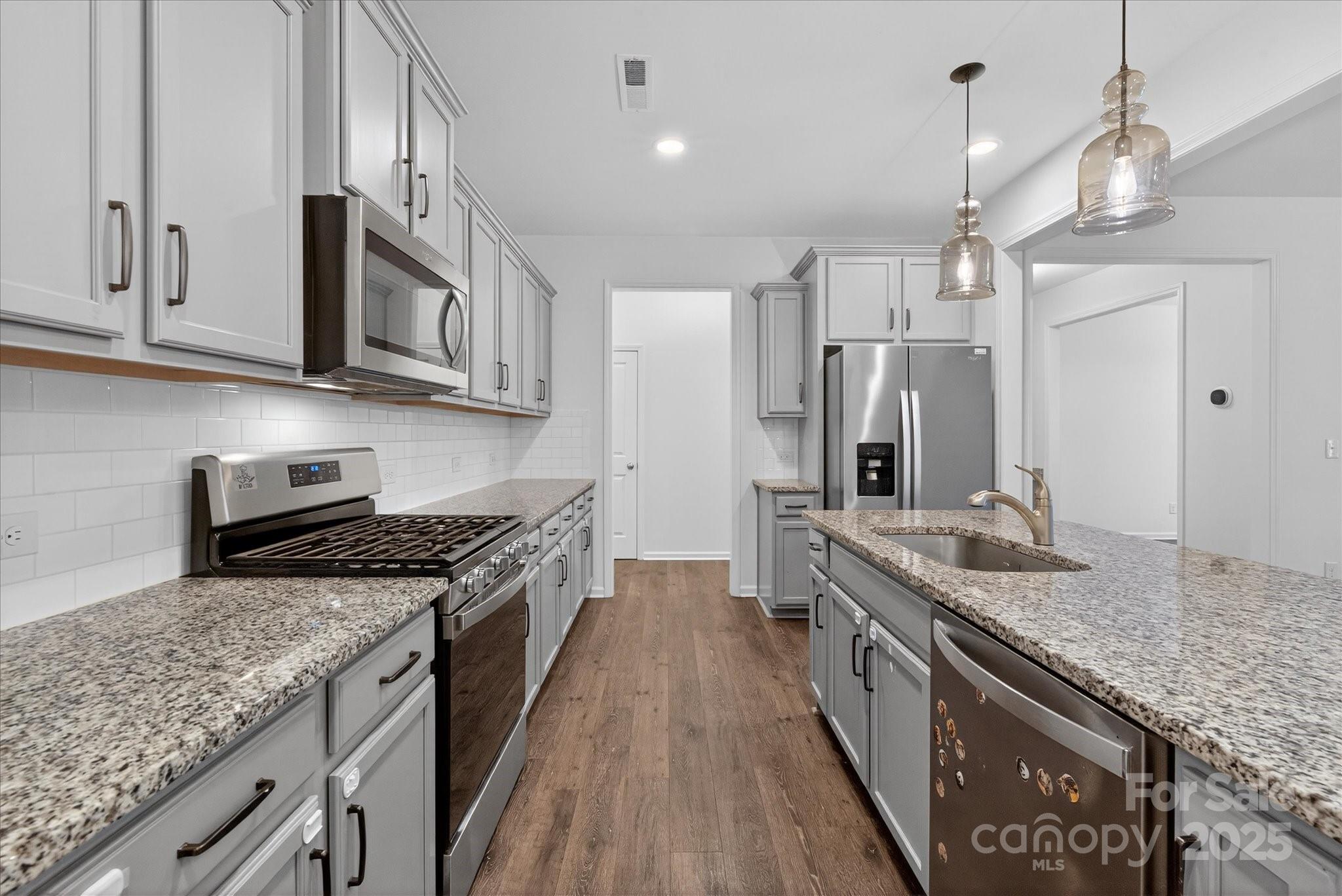 7481 Hartsfield Drive Lancaster, SC 29720 - Photo 5 of 47 a kitchen with stainless steel appliances granite countertop a stove a sink and a refrigerator
