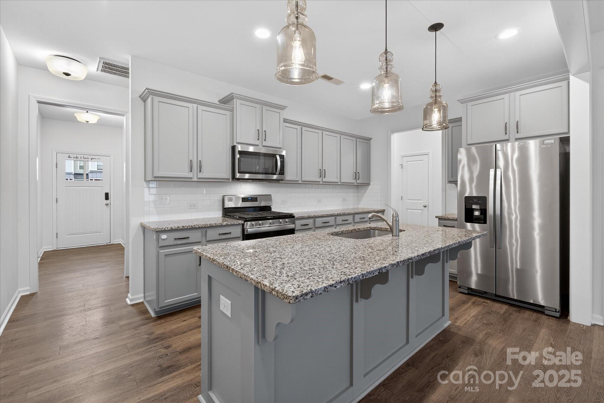 7481 Hartsfield Drive Lancaster, SC 29720 - Photo 6 of 47 a kitchen with stainless steel appliances granite countertop a sink refrigerator and microwave