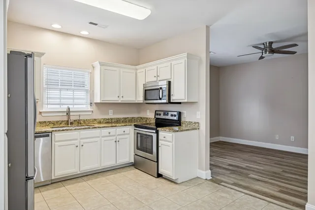 a kitchen with stainless steel appliances granite countertop a stove a sink and a refrigerator
