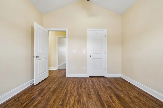 an empty room with wooden floor and a window
