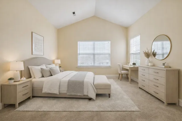 a bedroom with a bed a mirror and a window