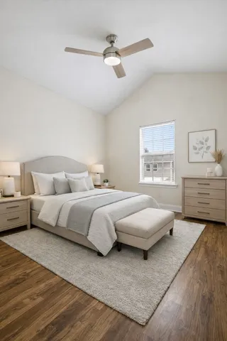 a spacious bedroom with a bed a couch and a painting on the wall