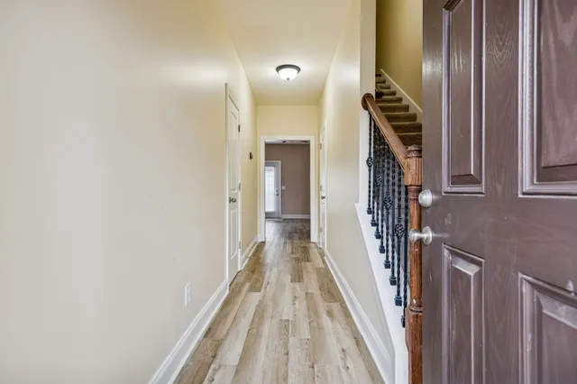 a view of a hallway with wooden floor and staircase