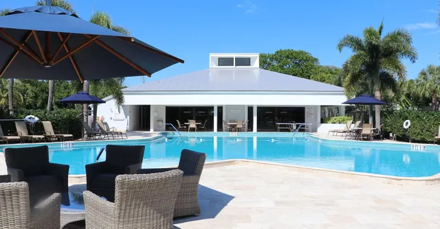 a view of a house with backyard sitting area and swimming pool