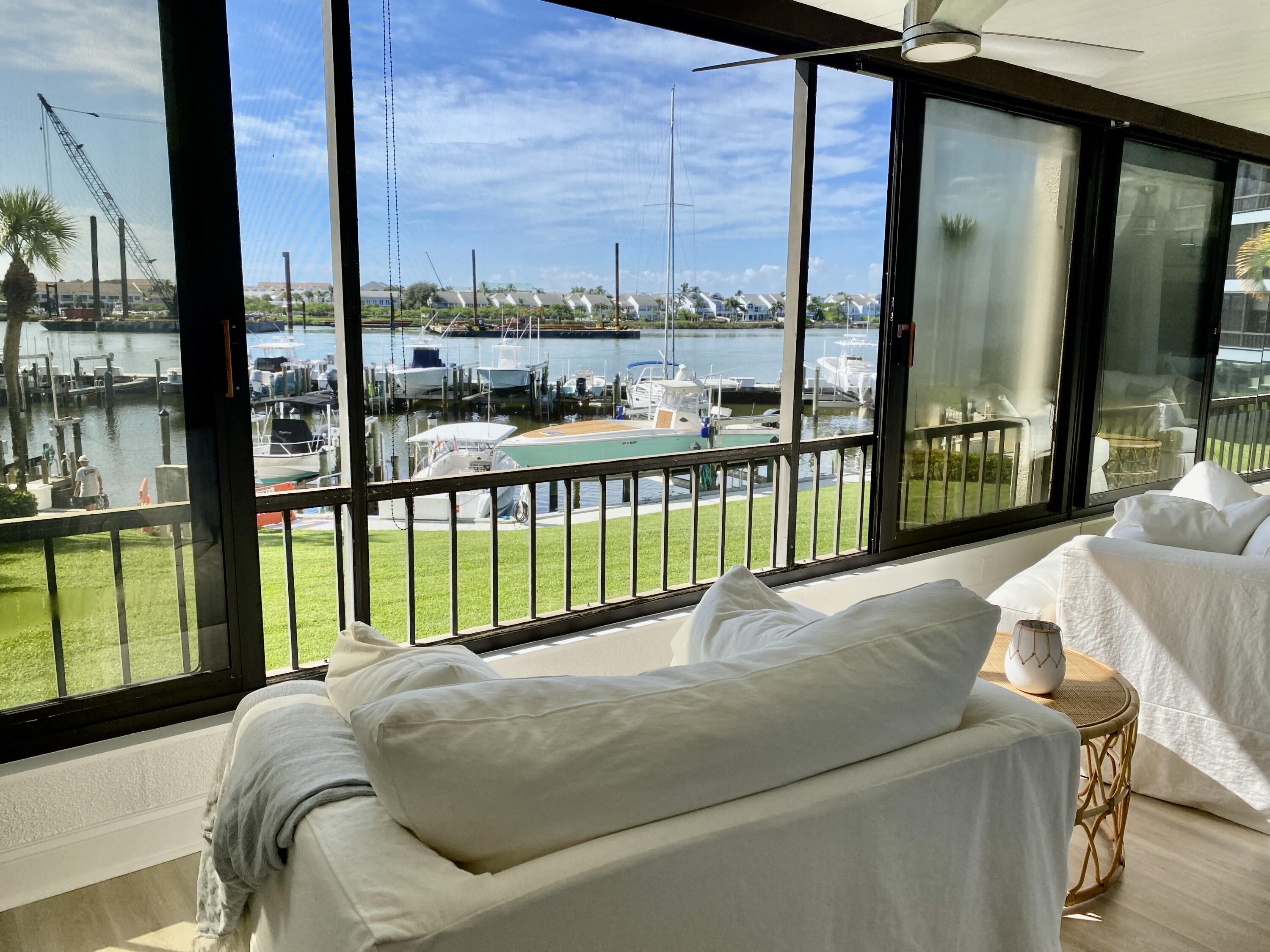 1648 Jupiter Cove Drive, Unit 210 Jupiter, FL 33469 - Photo 3 of 15 a bed sitting in a balcony next to a tall window