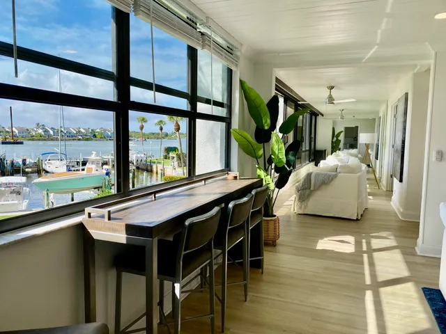 a living room with stainless steel appliances granite countertop a table and chairs with wooden floor