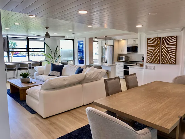 a living room with furniture kitchen view and a large window