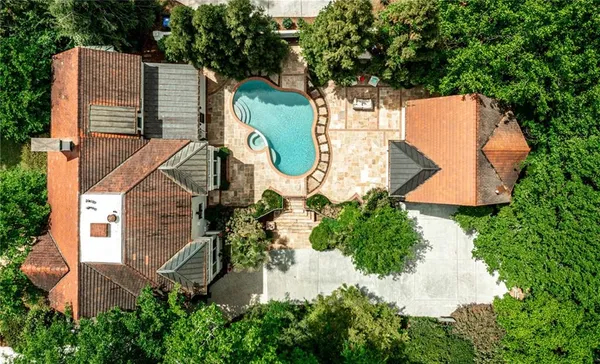 an aerial view of a house with yard and swimming pool