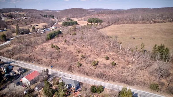 a view of a house with a yard and mountain view in back