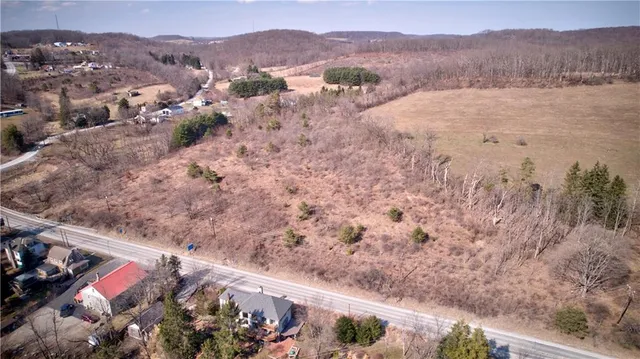 a view of a house with a yard and mountain view in back
