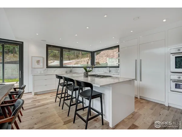 a kitchen with stainless steel appliances a table and chairs in it
