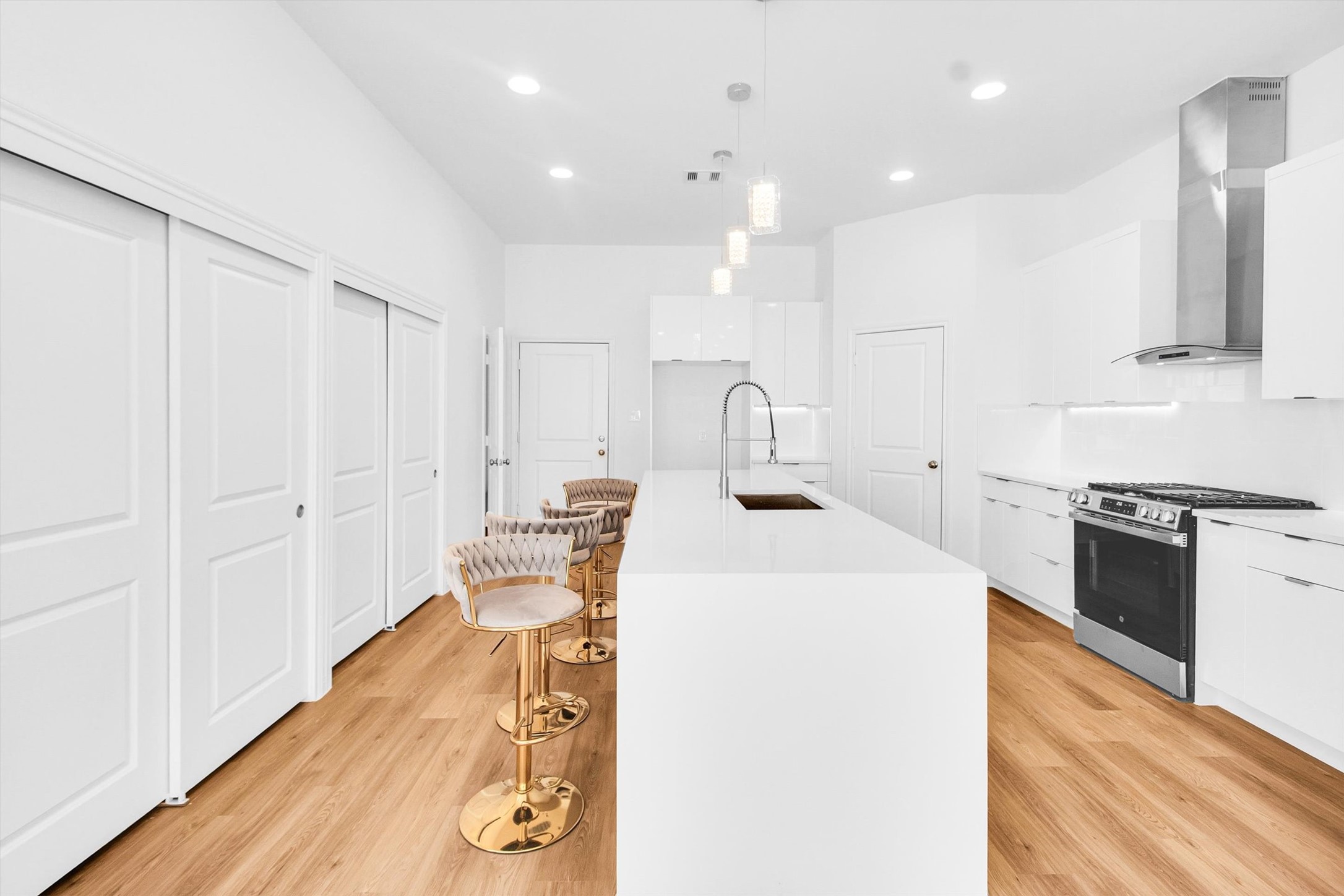 5323 Rue Street Houston, TX 77033 - Photo 6 of 34 a kitchen with kitchen island a stove a sink and a refrigerator with wooden floor