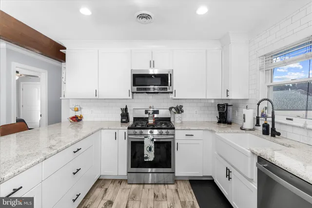 a kitchen with granite countertop white cabinets and white appliances