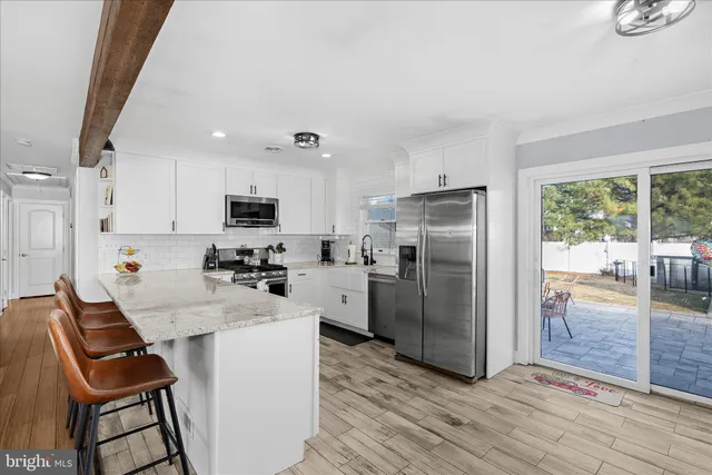a kitchen with refrigerator and chairs