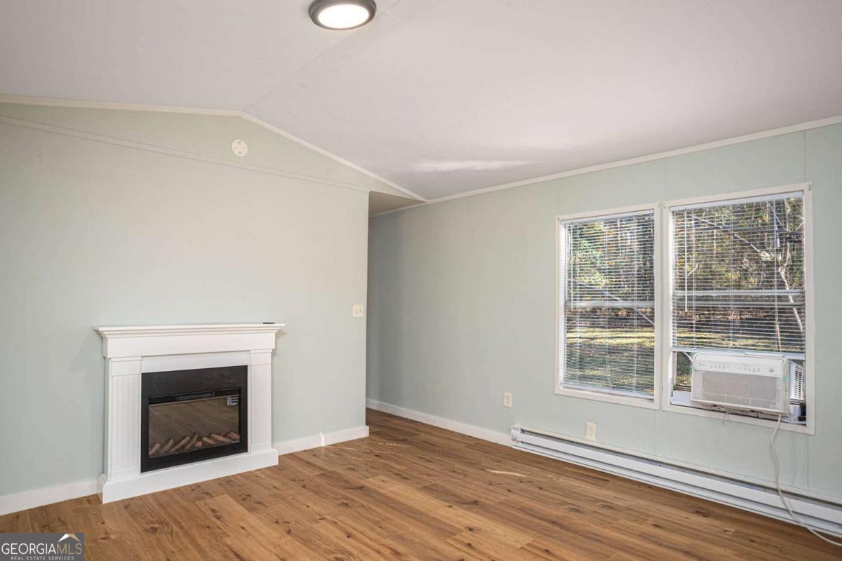 139 Anglin Road Jefferson, GA 30549 - Photo 12 of 26 wooden floor fireplace and windows in an empty room