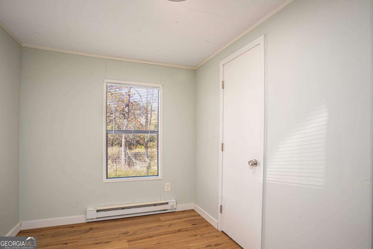139 Anglin Road Jefferson, GA 30549 - Photo 17 of 26 a view of an empty room with wooden floor and a window