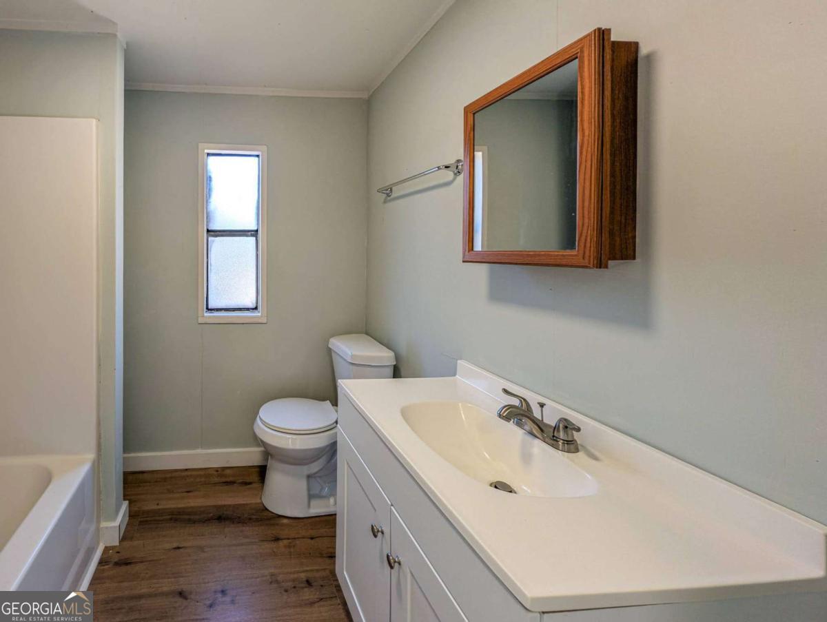139 Anglin Road Jefferson, GA 30549 - Photo 22 of 26 a bathroom with a toilet sink vanity and mirror