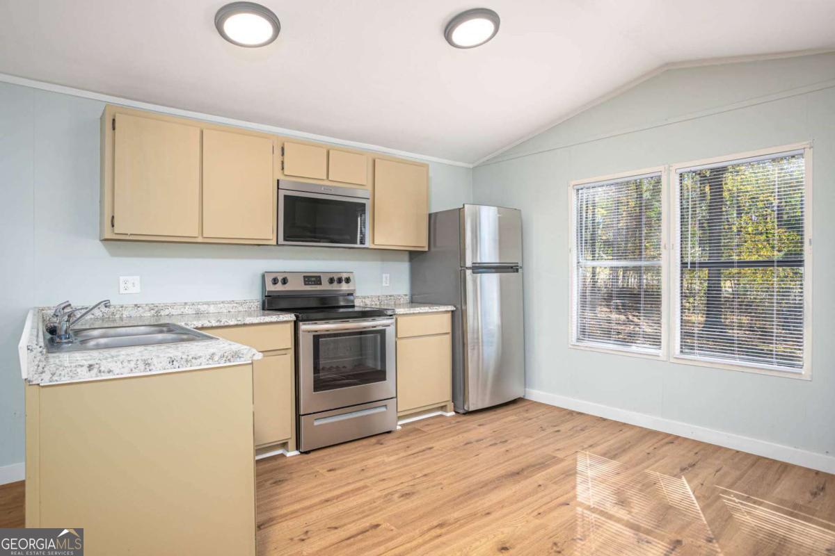 139 Anglin Road Jefferson, GA 30549 - Photo 8 of 26 a kitchen with a stove a sink and a microwave