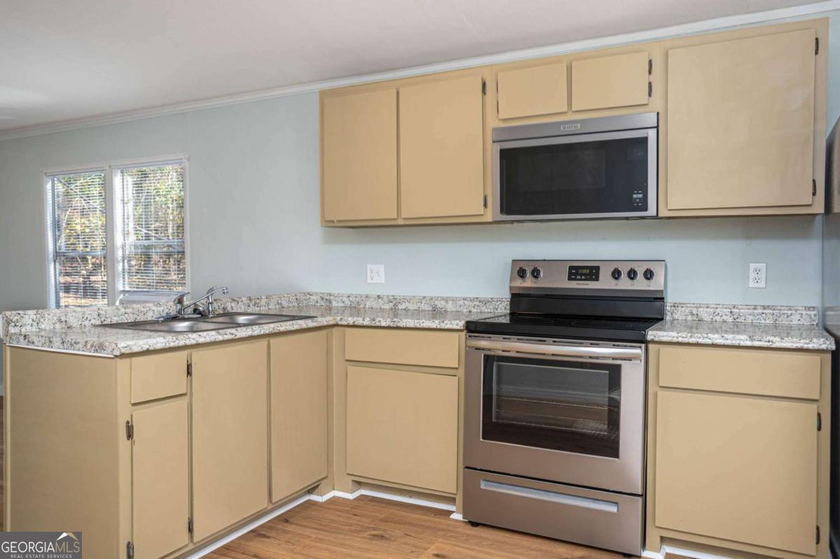 139 Anglin Road Jefferson, GA 30549 - Photo 9 of 26 a kitchen with granite countertop white cabinets stainless steel appliances and a sink