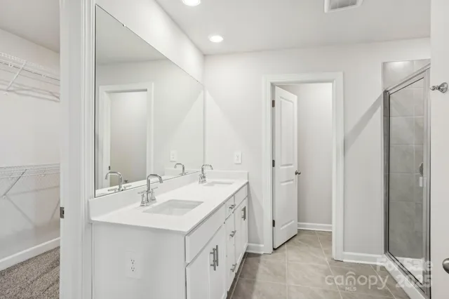 a bathroom with a double vanity sink mirror and shower